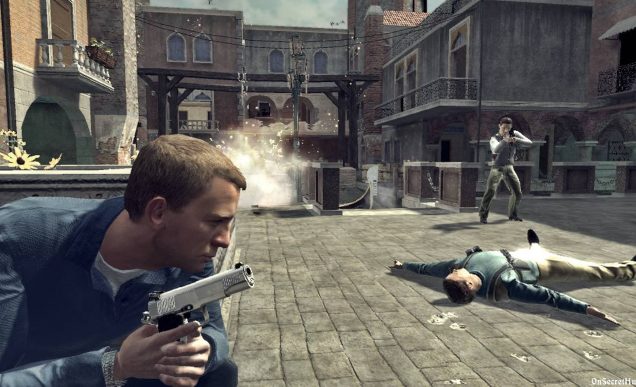 A video game version of Daniel Craig's James Bond hides behind cover whilst armed with a pistol, hiding from an armed man and an explosion in the distance. 