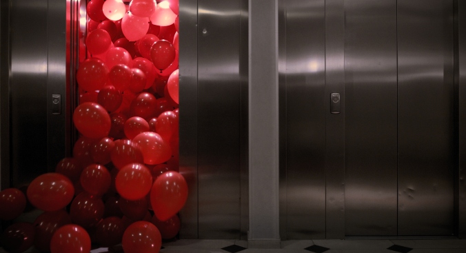 Red balloons falling out of an elevator in King On Screen