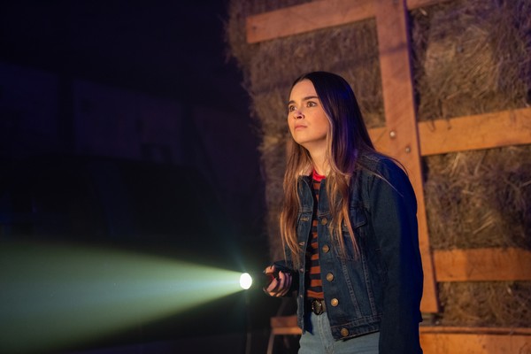 A girl shining a torch in the dark in a scene from Self-Help