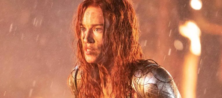 Matilda Lutz looks battle-damaged in a flaming scene from Red Sonja 2025.