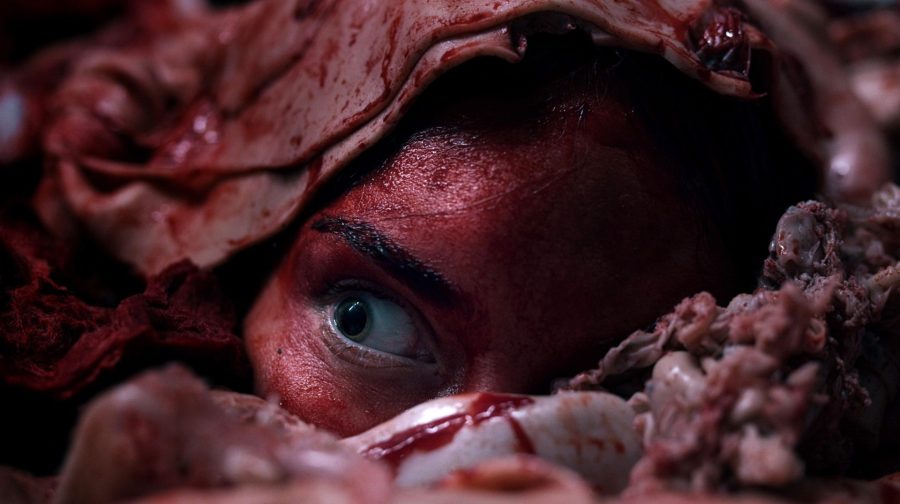 A woman covered in blood and meat in a scene from Meat Kills
