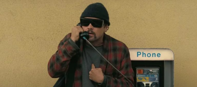 Leonardo DiCaprio frantically uses a pay phone in One Battle After Another.