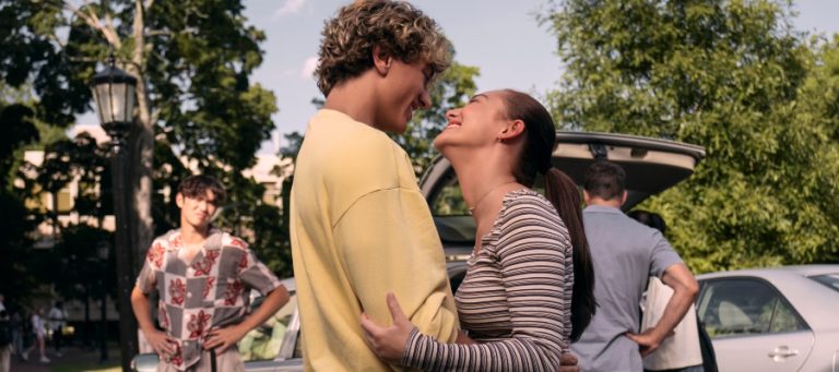 A man and a woman smile while holding each other in The Summer I Turned Pretty.