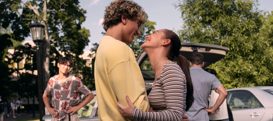 A man and a woman smile while holding each other in The Summer I Turned Pretty.