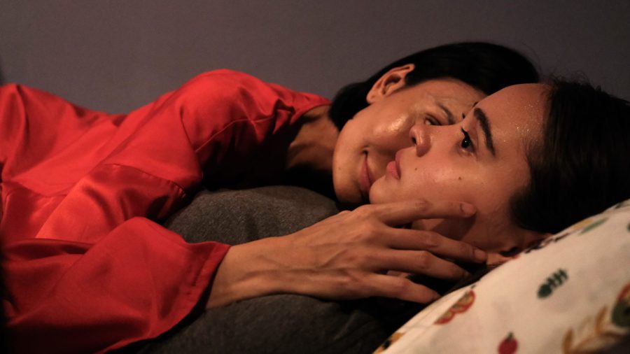 A woman cuddling her daughter with her hand around her neck in a scene from A Woman Called Mother