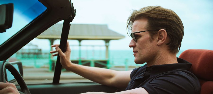 Matt Smith driving a car by the beach