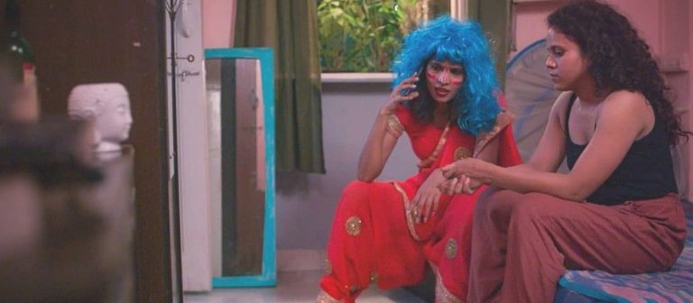 Two women chat on a bed in Songs of Forgotten Trees