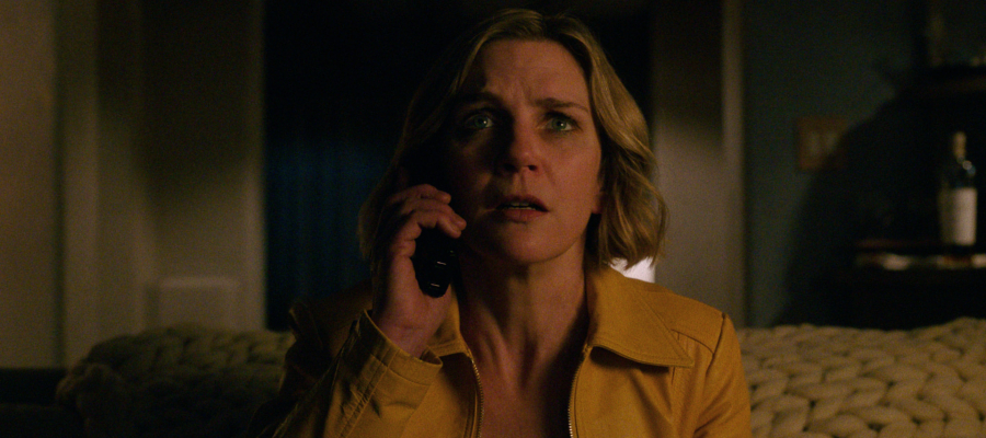 Carol Sturkha (Rhea Shorn) holds a phone and looks concerned.