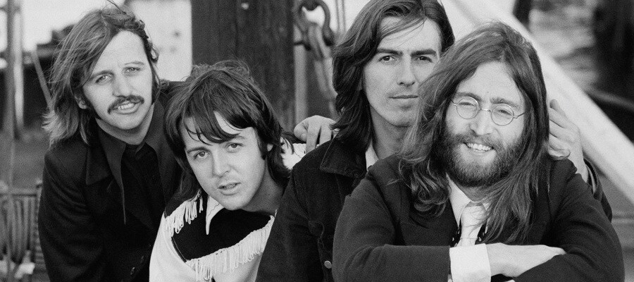 The four members of The Beatles pose together for a photo, which is in black and white.